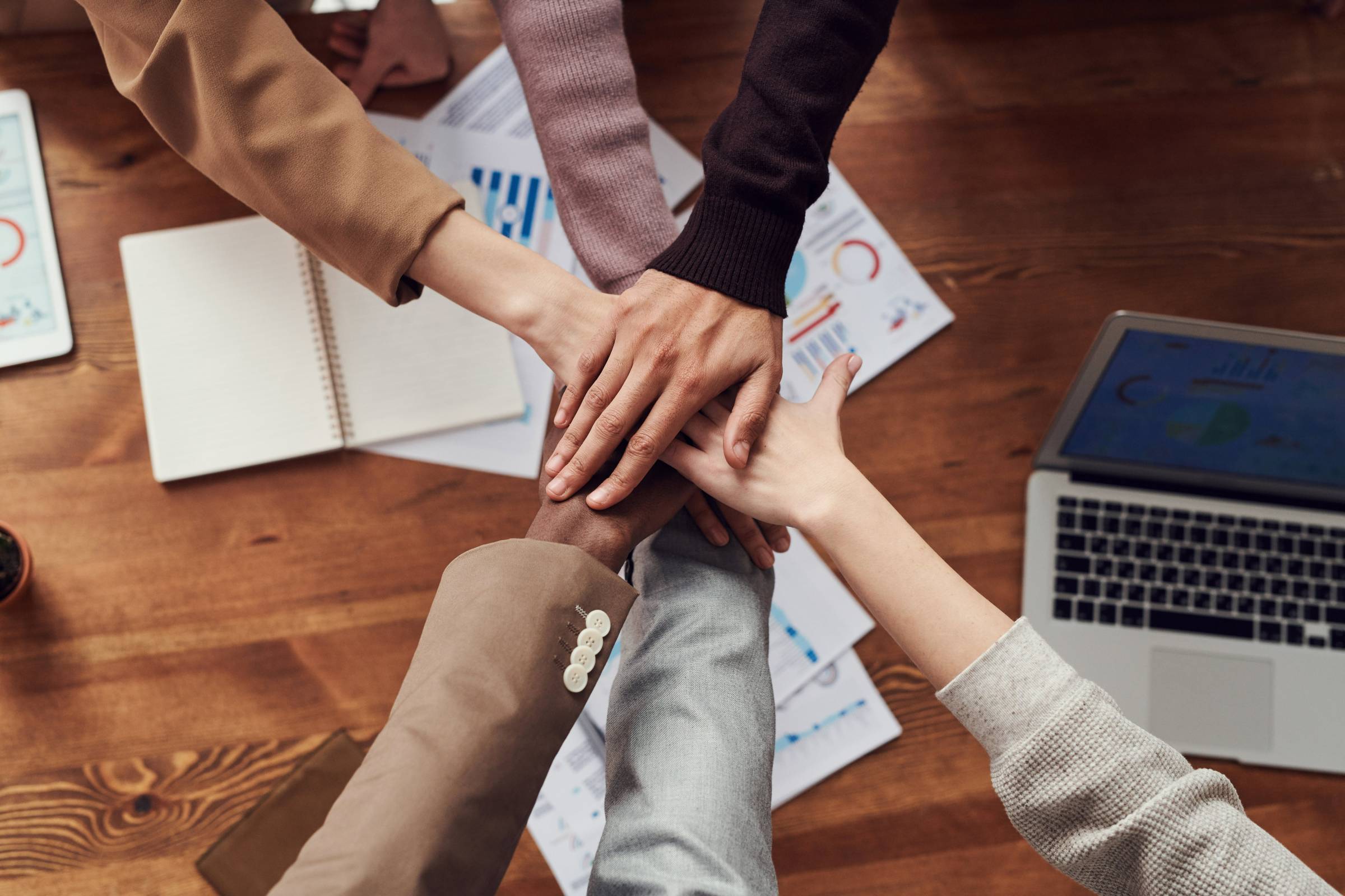 A team's hands together in a circle